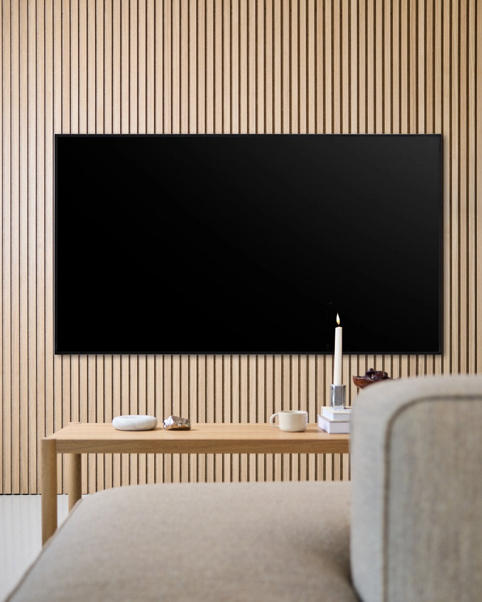 Moderne woonkamer met een aan de muur gemonteerde flatscreen-tv, Akupanel houten akoestische lattenwand en een houten salontafel voor een warme sfeer.